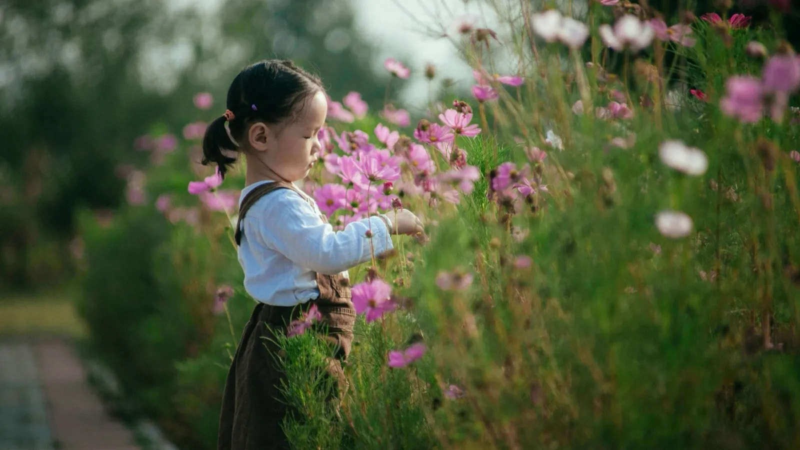 A young child holding a bunch of flowers outdoors